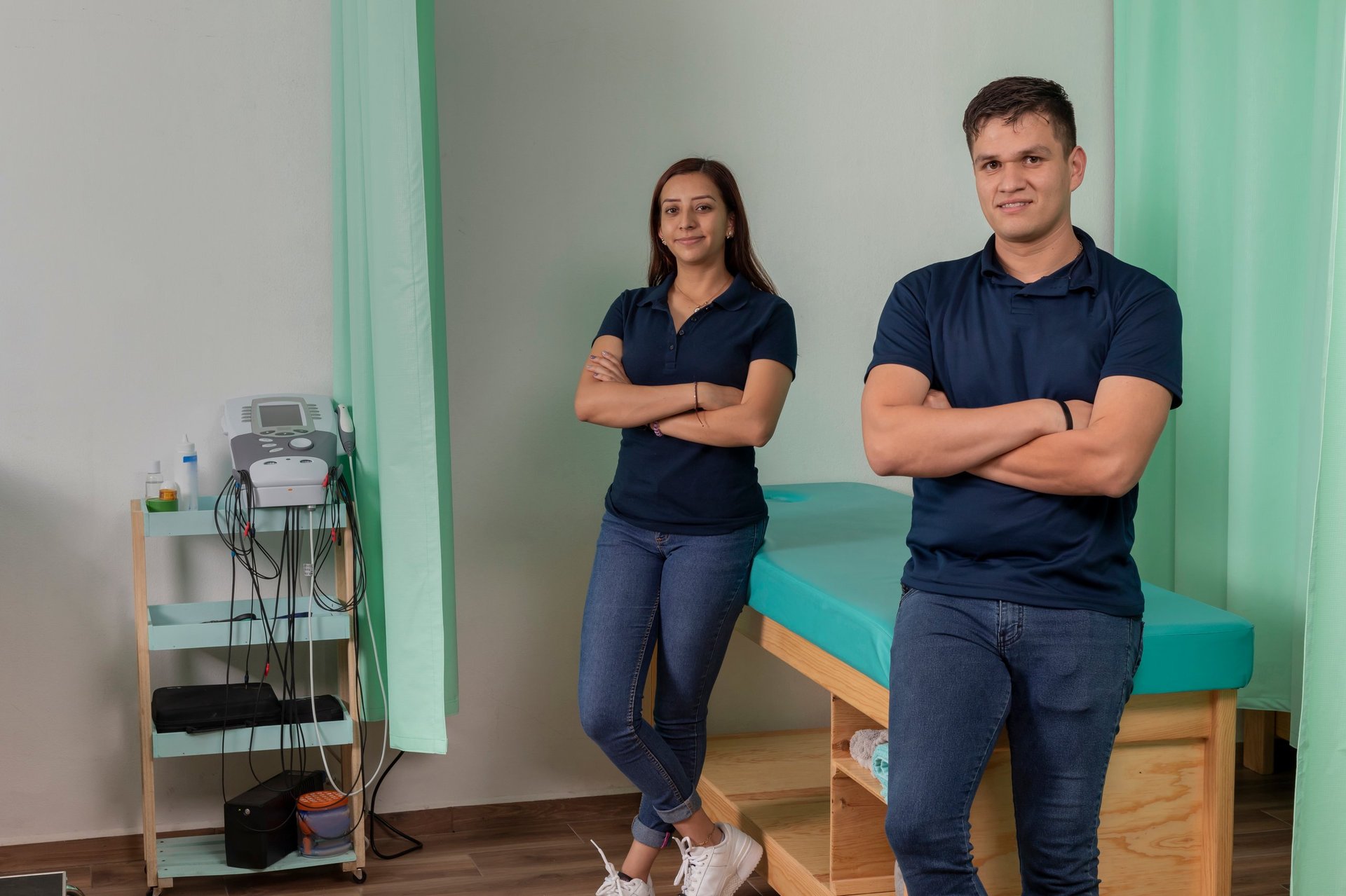 Physiotherapists standing confidently in clinic, healthcare professionals providing rehabilitation and physical wellness services